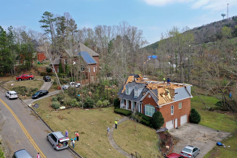 Repair work begins on heavily damaged homes along Eagle Point Drive in Birmingham, Ala., following a day of extended severe weather on March 26, 2021. (AP Photo/Vasha Hunt)