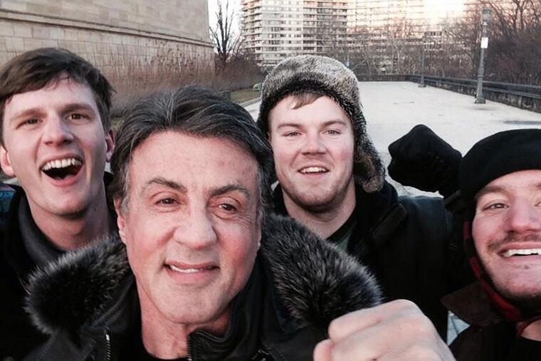 In this Jan. 17, 2015, photo provided by Peter Rowe, Rowe, right, takes a selfie with friends Jacob Kerstan, left, Andrew Wright, third from left and actor Sylvester Stallone in Philadelphia. Rowe said the three friends had just finished racing up the staircase at the city's Museum of Art when they saw Stallone. (AP Photo/Peter Rowe)