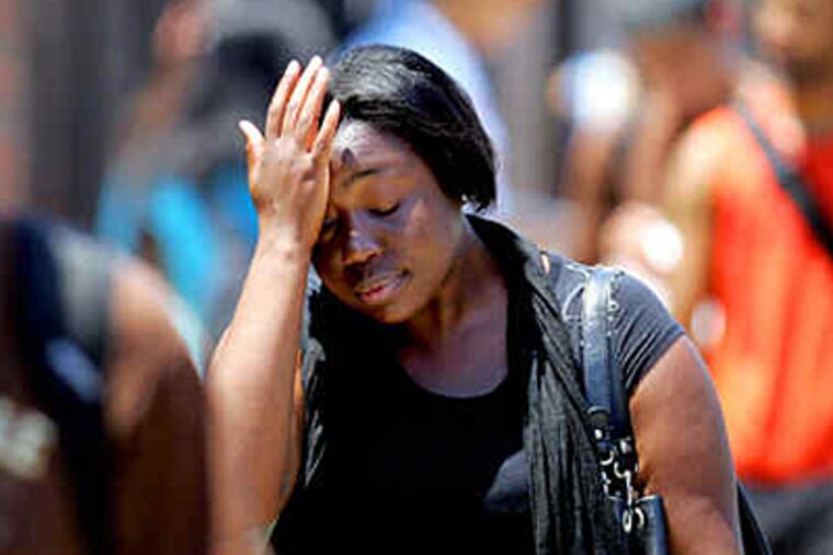 Zelda Acheampons walks home from classes at La Salle in June. The first week of that month produced the first heat wave, and two deaths. (David Swanson/Staff)