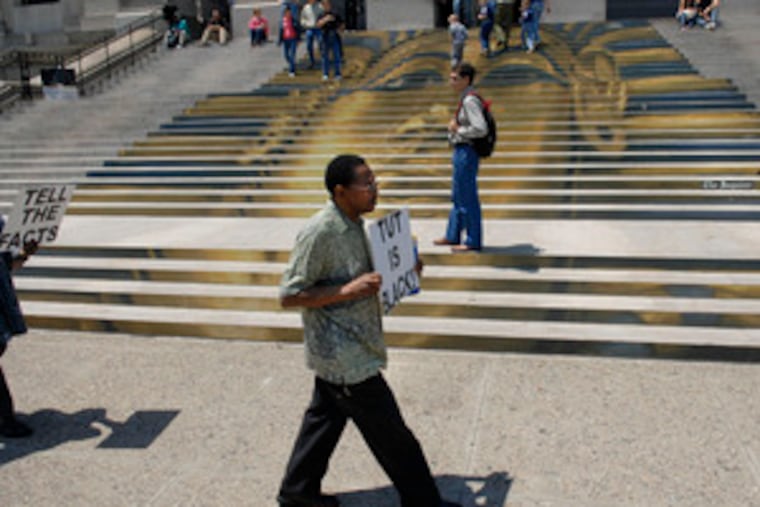 Protesters against King Tut exhibit carry signs in front of Franklin Institute yesterday.