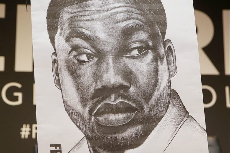 Meek Mill's mother, Kathy Williams, holds a poster of her son during a panel about criminal justice reform at the University of Pennsylvania's Irvine Auditorium