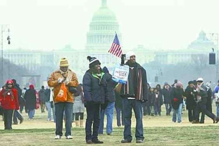 Joshua Dabney (right), of Atlanta, and his aunt Beanita Dabney, of Dallas, record the inauguration excitement with his video camera at the U.S. Capitol yesterday.