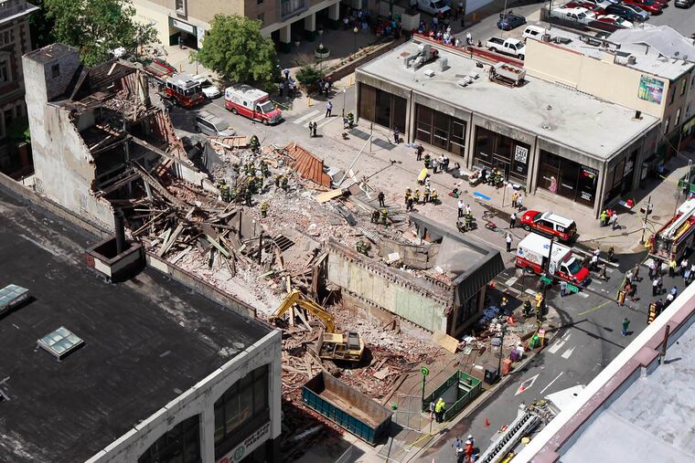 Firefighters remove debris by hand after a collapse at 22nd and Market. ( DAVID SWANSON / Staff Photographer )