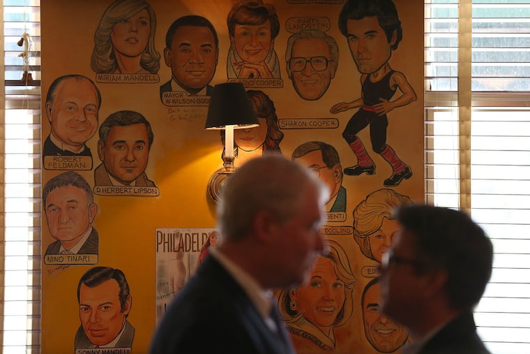 John Dougherty, left, business manager of IBEW Local 98, and councilman Bobby Henon, right, talk in front of some of the caricatures on the wall as they gather for a lunch at The Palm in Philadelphia, Pa. on May 20, 2015.