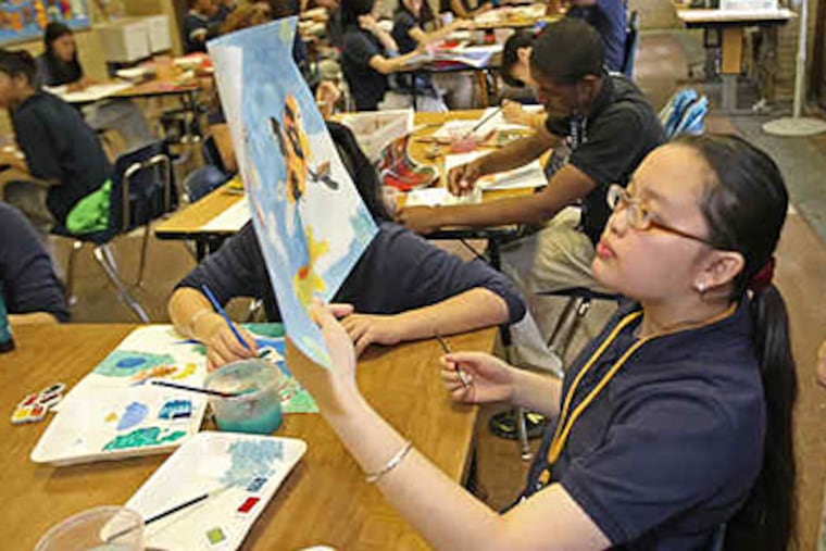Kathleen Nguyen, 14, examines the colors in her painting of koi. "I paint when I'm bored, or mad, or happy.It helps me express my feelings," she said. "I hope it makes the person who buys it happy, too." (Michael Bryant / Staff)