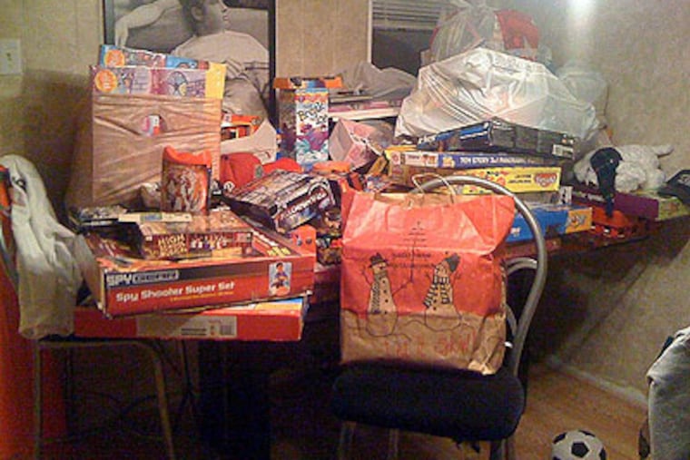 This year Billy Howell and his buddies' toy drive has been bigger than ever. Stocked on his dining room table are more than 150 toys they have collected for the children at St. Christopher's Hospital. (Photo by Kia Gregory)