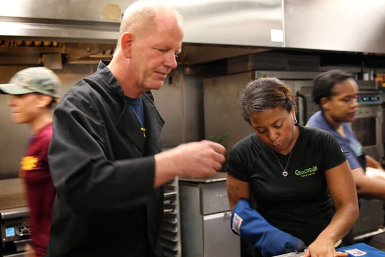 Kurt Linneman, executive chef and owner of Crocodile Cafe & Catering, tests a piece of brisket as Koren Griffin checks the meat. Linneman has developed hiring strategies. (DAVID MAIALETTI / Staff Photographer)