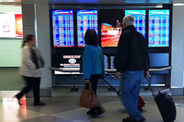 Travelers look at the Arrival and Departure board in Terminal D at Philadelphia International Airport on Wednesday, November 24, 2010. (Alejandro A. Alvarez / Staff Photographer)