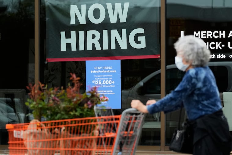 A hiring sign for sales professionals is displayed at a store in Vernon Hills, Ill.