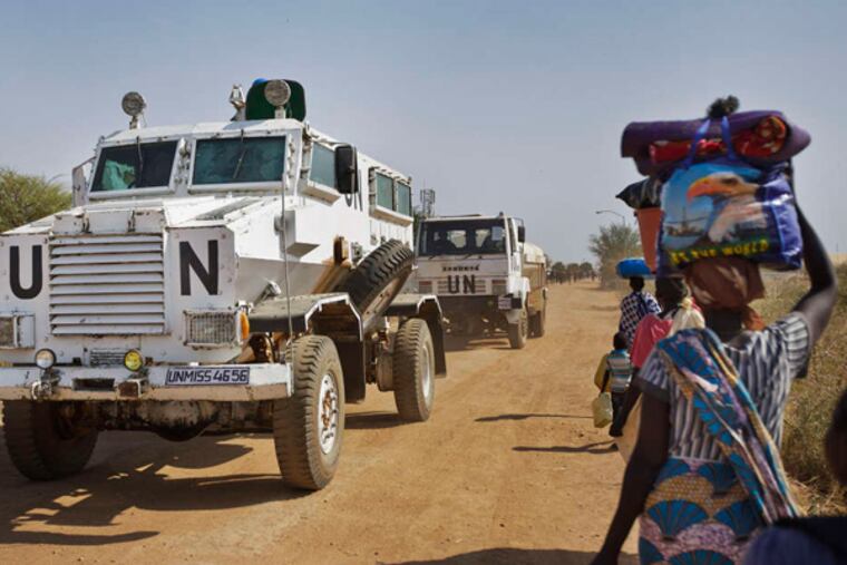 A United Nations vehicle passes people making their way to a U.N. shelter in Malakal, South Sudan. (Ben Curtis / AP)