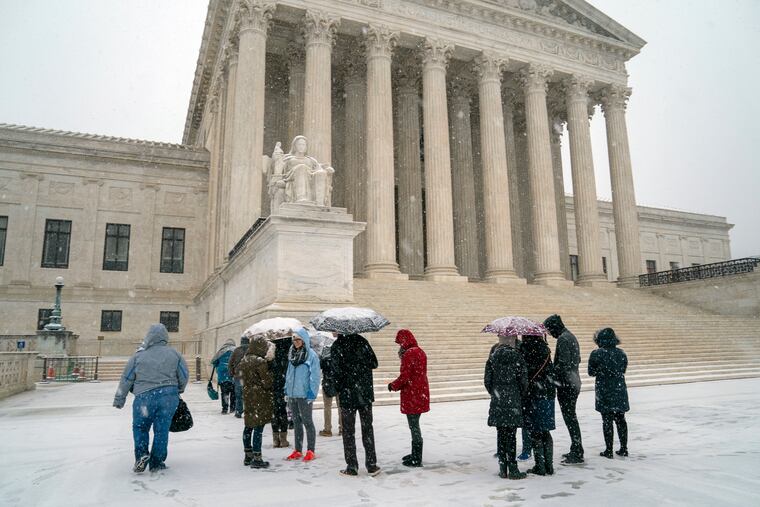 Visitors wait to enter the Supreme Court as a winter snow storm hits the nation's capital making roads perilous and closing most Federal offices and all major public school districts, on Capitol Hill in Washington, Wednesday, Feb. 20, 2019. The Supreme Court is ruling unanimously that the Constitution's ban on excessive fines applies to the states. The outcome Wednesday could help an Indiana man recover the $40,000 Land Rover police seized when they arrested him for selling about $400 worth of heroin. (AP Photo/J. Scott Applewhite)