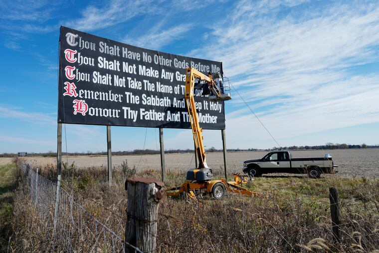Workers repaint a Ten Commandments billboard off of Interstate 71 near Chenoweth, Ohio, on Nov. 7, 2023. Louisiana has become the first state to require that the Ten Commandments be displayed in every public school classroom under a bill signed into law by Republican Gov. Jeff Landry on Wednesday.