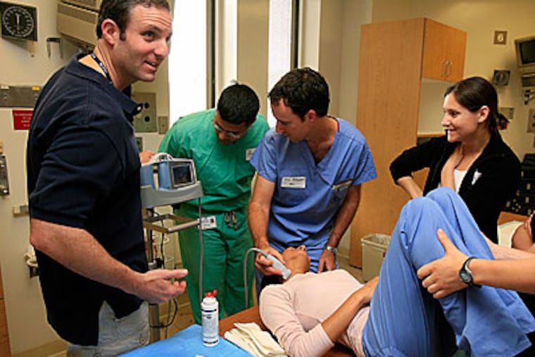 Dr. Roger Band, Univ. Penn Emergency Medicine (left) teaches med students how to use a portable ultrasound machine for central venous catheter procedure. (Akira Suwa / Staff Photographer )