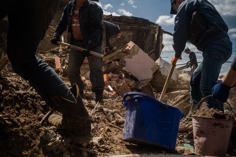 Volunteers working on clearing rubble from a damaged section of Kharkiv in May.