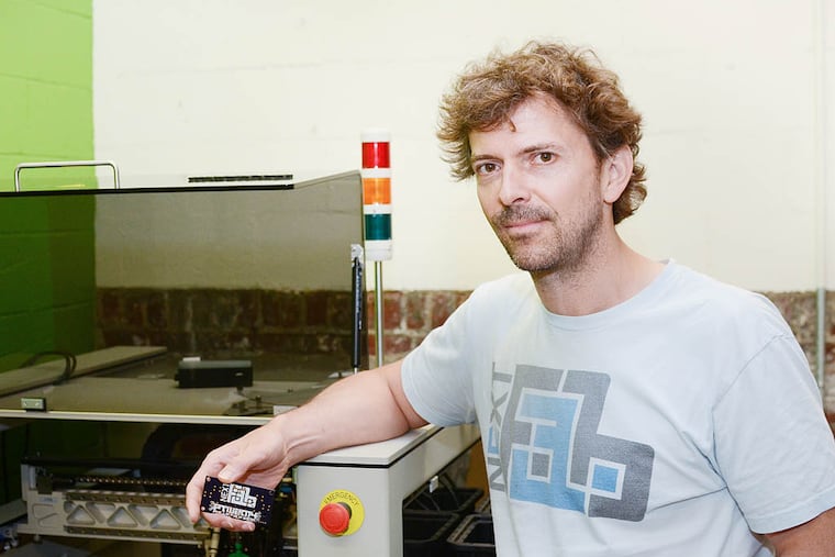 NextFab founder & president Evan Malone stands next to a pick-and-place machine, which assembles circuit boards. NextFab provides training and access to cutting-edge manufacturing technologies.