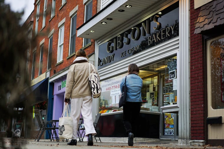 In this Nov. 22, 2017 file photo, pedestrians pass the storefront of Gibson's Food Mart & Bakery in Oberlin, Ohio. A jury has awarded $11 million to a father and son who claimed Ohio's Oberlin College and an administrator hurt their business and libeled them during a dispute that triggered protests and allegations of racism following a shoplifting incident.