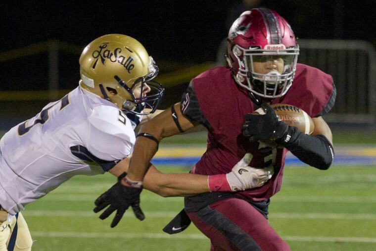 La Salle’s Sean Daly tries to take down St. Joseph’s Prep’s James Cherry during the first half of Friday night’s game.