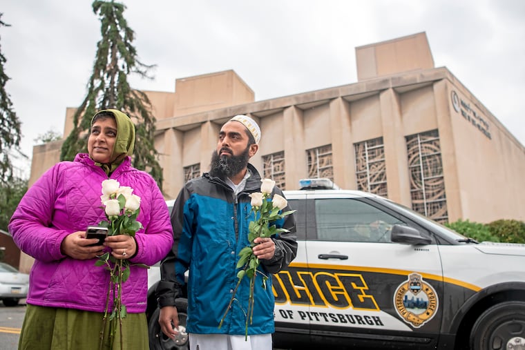 Samina Mohamedali, left, and her husband Kutub Ganiwalla, members of the Dawoodi Bohra Muslim community, both of North Hills, prepare to place flowers on a memorial in front of the Tree of Life Congregation, Sunday, Oct. 28, 2018, in Squirrel Hill neighborhood of Pittsburgh.