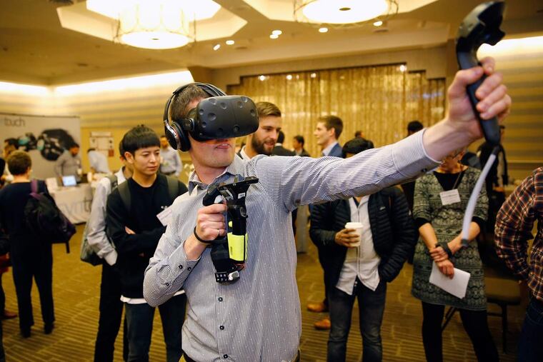 Ryan Schindeler, of Ontario, Canada, tries out a souped-up video-game controller developed by Tactical Haptics.