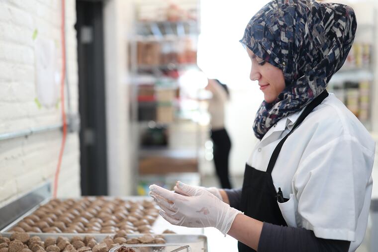 Bdour Hussein, a refugee from a war-shattered Syria, works as a prep cook at Suraya restaurant in Philadelphia.
