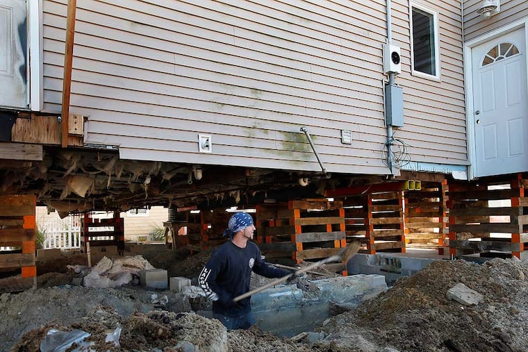 In Brick, NJ, Mattew Hills prepared the foundation of a house damaged by Hurricane Sandy. The raised house, seen here in October 2014, rests on supports as a higher foundation is built.