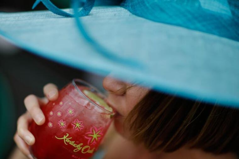 Lori Thomas, from Nashville, Tenn., drinks a "Lilly" before the running of the 139th Kentucky Oaks at Churchill Downs Friday, May 3, 2013, in Louisville, Ky. (David Goldman/AP)