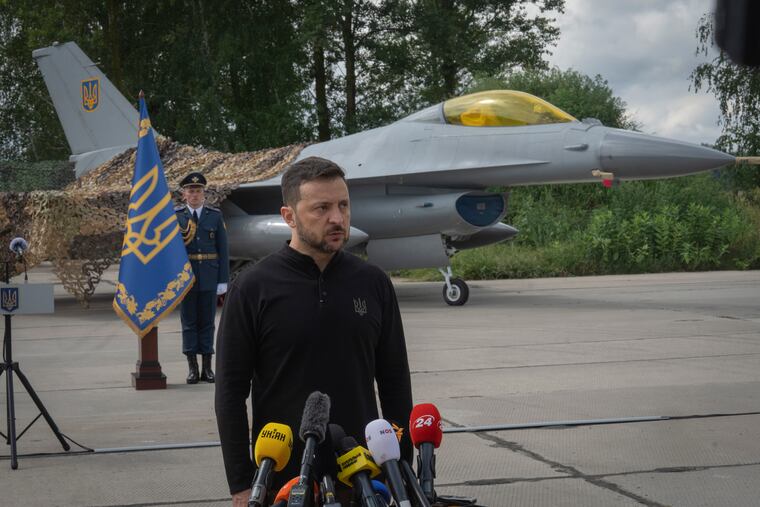 Ukraine's President Volodymyr Zelenskyy answers media questions standing against the background of Ukraine's Air Force's F-16 fighter jets in an undisclosed location in Ukraine on Sunday. The F-16 fighter jets that have been delivered to Ukraine by Western countries will be flying sorties in Ukrainian skies and helping the country's current fleet of Soviet-era jets to counter Russia's invasion.
