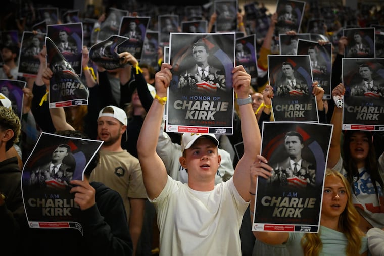 People hold posters of Charlie Kirk during a Turning Point USA rally on Sept. 30 at Utah State University in Logan, Utah, as a part of the organization's push to memorialize Kirk.