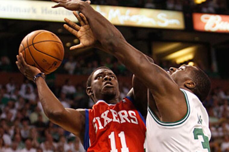 Jrue Holiday scores despite a foul by the Celtics' Brandon Bass in the first quarter of Game 7. (Ron Cortes/Staff Photographer)