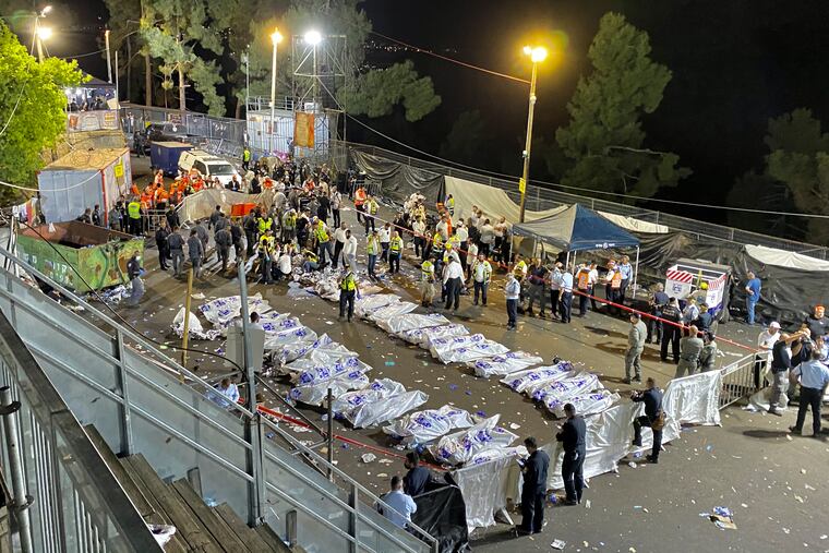 Israeli security officials and rescuers stand around the bodies of victims who died during a Lag Ba'Omer celebration at Mt. Meron in northern Israel.