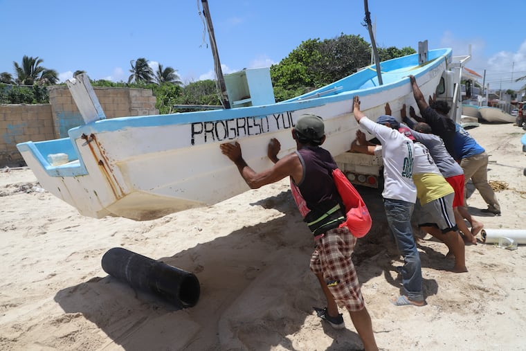 People relocate a boat for its protection ahead of the arrival of Hurricane Beryl in Progreso, Mexico, on Thursday, July 4, 2024.