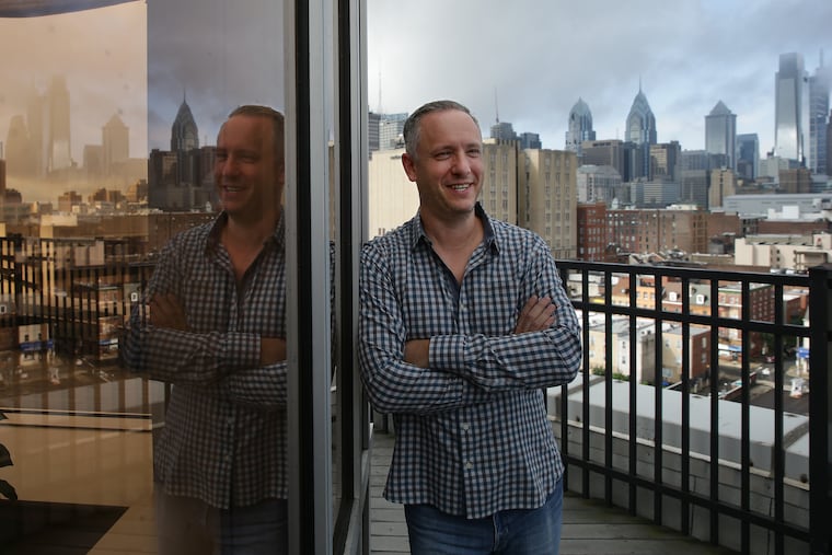 Sean Fogler is reflected in a window outside his condo outside Chinatown. D