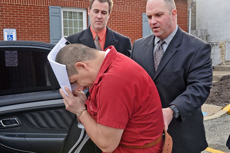 David Pacheco covers his face as he is escorted from court. He was arraigned on various charges.