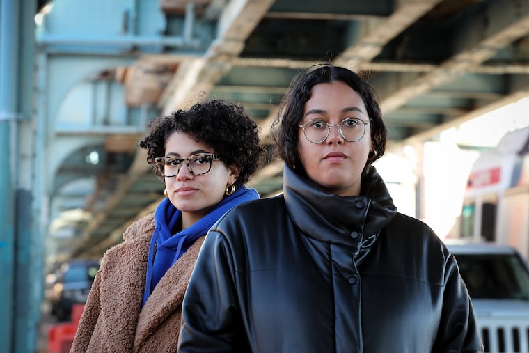 Joia McManus (left) and Xiomara Torres (right), former Youth United for Change staffers, pose for a portrait outside the former YUC office on Sunday, Jan. 15, 2023, in Philadelphia, Pa. The staff of Youth United for Change, which organizes students in Kensington and citywide, filed a complaint with the National Labor Relations Board last year, alleging their executive director broke the law by disciplining them after they collectively asking for a raise. YUC and its former staffers settled late last year.