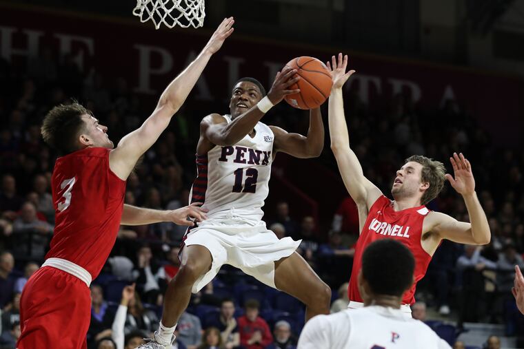 Penn's Devon Goodman drives to the basket between Cornell's Jimmy Boeheim (left) and Greg Dolan (right) during the second half.
