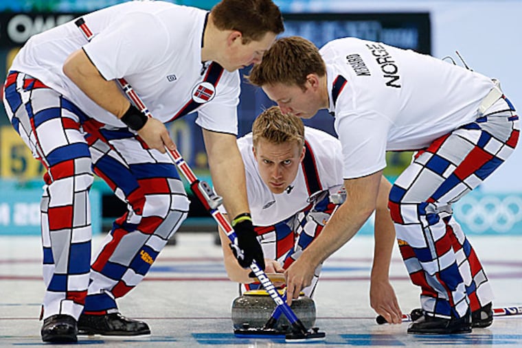 Norway's Haavard Vad Petersson releases the rock to his sweepers Christoffer Svae and Torger Nergaard during men's curling competition. (Robert F. Bukaty/AP)