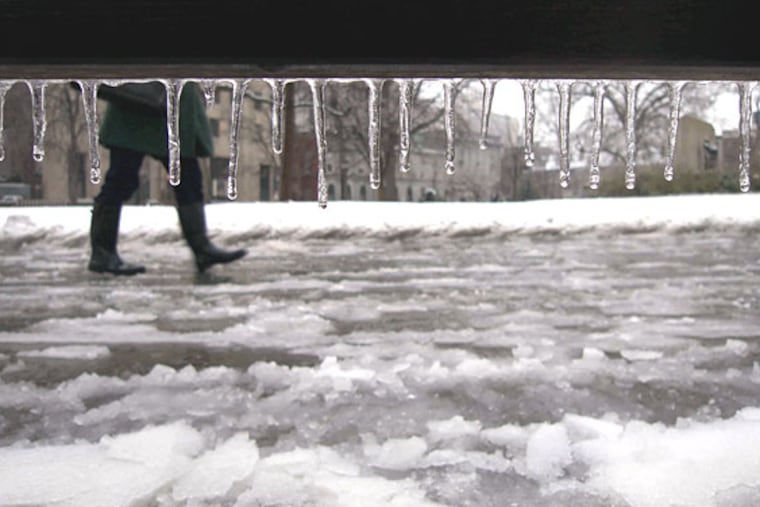 A pedestrian trudges through the wintry mix in Washington Square Park in Philadelphia.