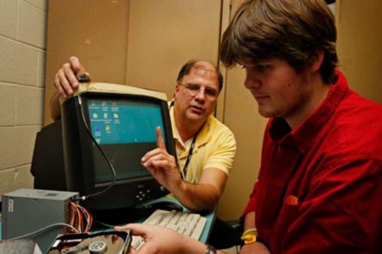 Dave Tatum (left), a network instructor, explains the workings of a hard drive and how to recover lost data to Nick Lynch,17. (Michael S. Wirtz / Staff Photographer)