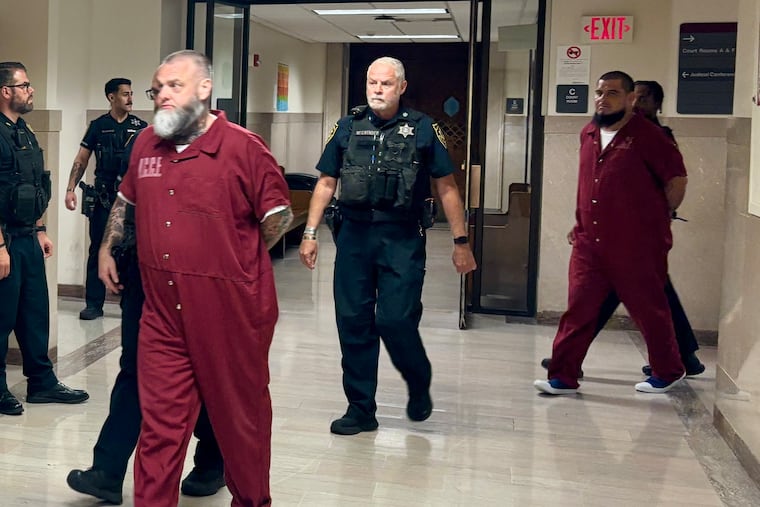 George Cwienk III (left) and Joel Hernandez-Martinez are escorted out of a courtroom in the Montgomery County Courthouse on Monday. The two members of the Pagans outlaw motorcycle club are on trial this week for their alleged roles in a shooting at a Wawa in West Norriton last year.