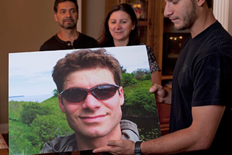 Parents Christian and Patricia Miranda and son Kevin, who holds a photo of his big brother, Navy SEAL Denis Miranda, killed in September in Afghanistan. (Ed HIlle/Staff)