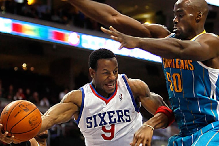 Andre Iguodala passes the ball around New Orleans Hornets' Emeka Okafor, right. (David Maialetti/Staff Photographer)