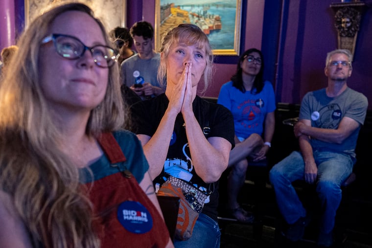 Lori Lahrmann (left) and Tonya Morris (second from left), both from Cincinnati, watch the presidential debate between President Joe Biden and Former President Donald Trump at Tillie's Lounge in Cincinnati on Thursday. Both plan to vote for President Joe Biden.
