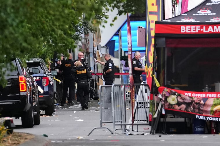 A crime scene photographer arrives as law enforcement examines the scene following a shooting at Seattle Center during the Bite of Seattle food festival Sunday, July 26, 2026, in Seattle.