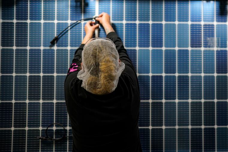 An employee works on a solar panel inside the Hanwha Qcells Solar plant on Oct. 16, 2023, in Dalton, Ga.