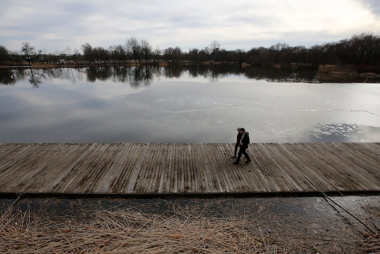 Visitor to FDR Park in South Philadelphia walk on the docks near the Boathouse at Edgewood Lake on Friday, February 26, 2021.