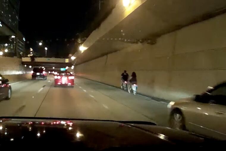 A video captured by a driver's dashcam shows two people using Indego, the city's bike-sharing system, heading westbound on Interstate 676 around 10 p.m.