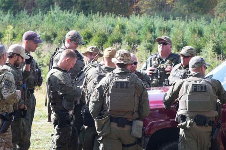 FBI agents searching for Eric Frein gather for a briefing on a field near a tree nursery along Route 447 in Canadensis, Pa. (Ed Hille / Staff Photographer)