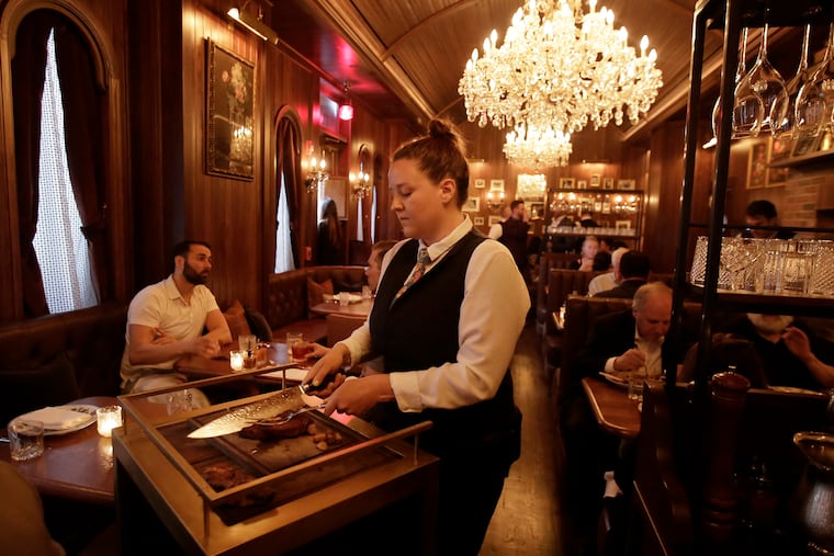 Server Erin Carroll carves a bone-in rib-eye at Alpen Rose.