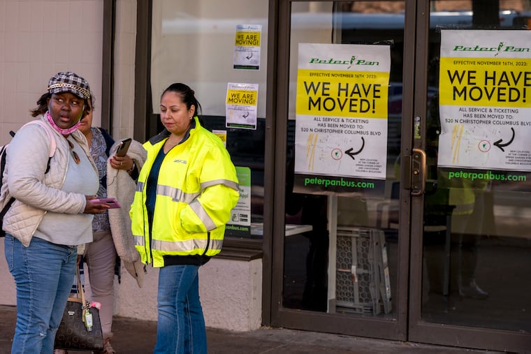 A bus company worker (right) assists a rider who arrived with a bus ticket not knowing the terminal for intercity buses was moved from the 600 block of Market Street to a new temporary area at Spring Garden Street and Delaware Avenue.