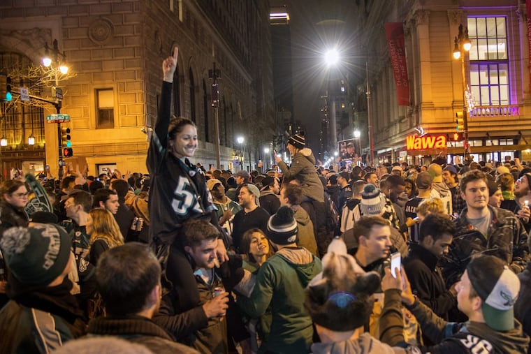 Eagles fans take to the streets at Broad and Walnut to revel in the victory against the Vikings. TOM GRALISH / Staff Photographer